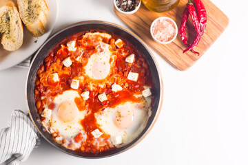 Shakshuka made of poached eggs in tomato pepper sauce