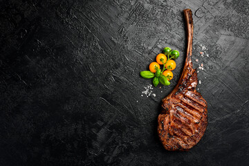 Tomahawk steak on the bone. Prime Black Angus beef steak on a black slate background. Top view.