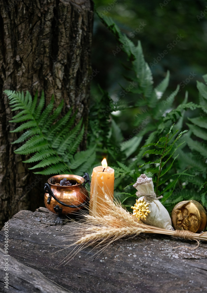 Wall mural cauldron, candle, witch bag, wheat ears and symbolic moon amulet in forest, natural background. Witchcraft, magic practice. esoteric spiritual ritual for for Lammas, Lughnasadh.