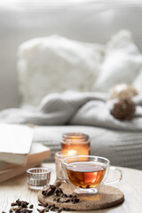 Still life with a cup of tea, books and a candle in a candlestick.