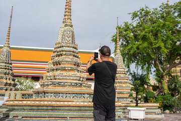 Asian male tourist in Buddha temple, Wat Pho Temple in Bangkok city, Thailand.