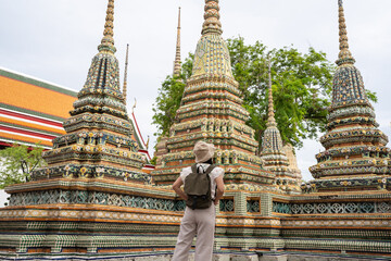 Asian women tourists with backpacks travel to Wat Pho Temple, Bangkok City, Thailand.