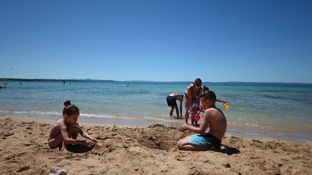 Family Fun Building Sandcastles at the Beach of Zaton, Croatia.