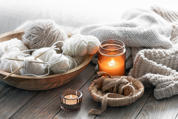 A cozy composition with threads, a candle . Hobby and home comfort concept.