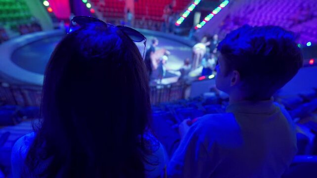 Spectators in a circus. Woman with teenage boy waiting for a circus performance to begin. Simferopol, Crimea, Russia 2024