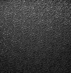 Corrugated glass, black dark background. Glass texture. glass pattern surface. Corrugated window glass with light reflection in night. monochrome dark background. Shiny rippled glass glow in darkness