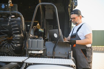 Truck repair service. Mechanic makes computer diagnostic of the semitruck