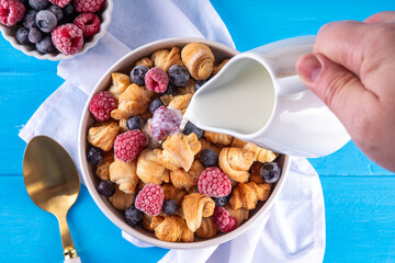 Tiny breakfast croissant cereals with fresh berries and milk