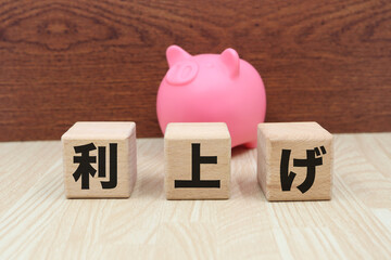 ピンクの豚の貯金箱と利上げの文字