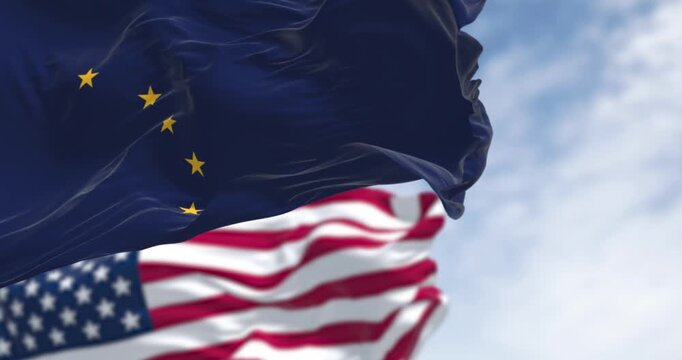 Alaska state flag waving in the wind behind the national flag of the US