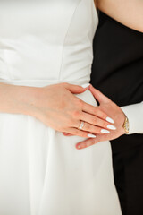 Obraz premium Groom hugging bride. Cropped photo. Groom in black suit. Details