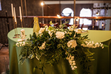 The newlyweds' presidium in the restaurant's banquet hall is decorated with candles and green plants.wedding day