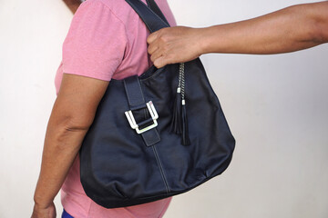 Thief hand  snatching the bag  from woman. Concept, Criminal pickpocket and crimes. Snatcher stealing  handbag. Steal  money wallet from other people, type of crime.  A thief who picks pockets.       