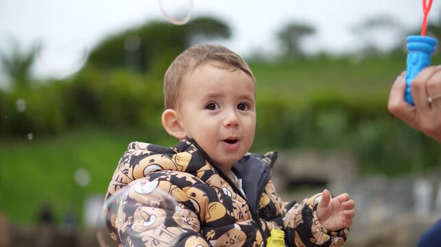Crian&ccedil;a em um parque brincando com bolhas de sab&atilde;o