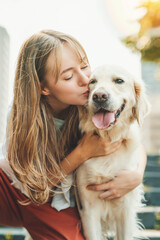 Portrait of teenage girl having fun outside with golden retriever