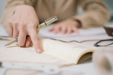 The architect carefully sketches a detailed design drawing by hand, shaping the blueprint for a significant architecture project, blending business acumen with engineering precision.