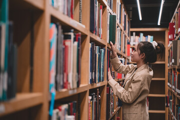 In the university library, a young female student immersed in her studies is carefully choosing literature, embodying the essence of education and the pursuit of knowledge indoors.