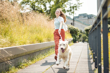 Portrait of teenage girl having fun outside with golden retriever
