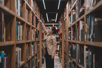 In the university library, a young female student immersed in her studies is carefully choosing literature, embodying the essence of education and the pursuit of knowledge indoors.