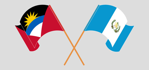 Crossed and waving flags of Antigua and Barbuda and Republic of Guatemala