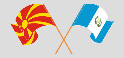 Crossed and waving flags of North Macedonia and Republic of Guatemala