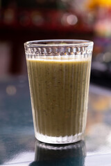 A glass of healthy green smoothie on the table in the bar.