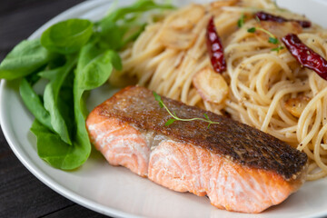 A delicious and healthy meal of grilled salmon with spaghetti and vegetables.