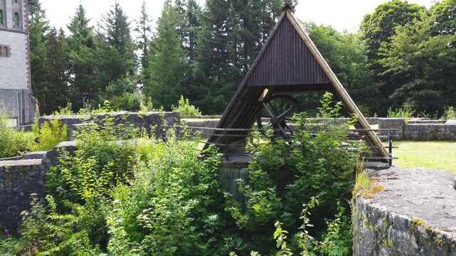 Drohnenaufstieg vom Burgraben zur Burgruine mit Fokus auf historisches Brunnenhaus