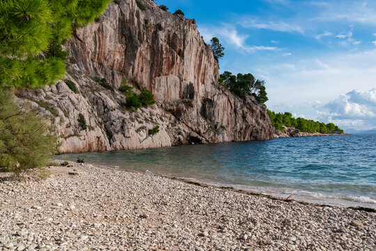Scenic view of idyllic pebble beach Nugal along Makarska Riviera, Split-Dalmatia, Croatia, Europe. Picturesque coastal scene nestles between towering majestic cliffs at Adriatic Mediterranean sea