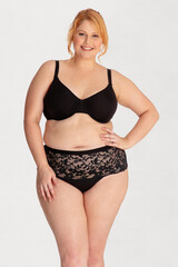 Fototapeta premium Portrait of a attractive young woman plus size in underwear model posing isolated on a white background mockup. White female, laughing and feeling confident. Clipping path. Body positivity - AI photo