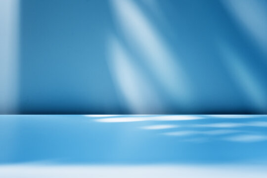 Blue background with blurred light and shadows on  wall. Winter background  for product presentation.
