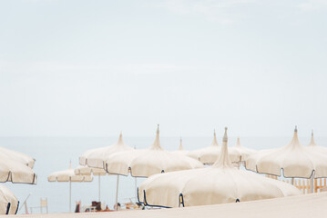 Parasols blanc sur une plage italienne. Toits de parasols sur la plage. Vacances à la mer. Hauts de parasols en pointe. Sommets de parapluies blancs. Style byzantin