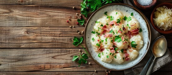 Top view of Slovak potato dumplings halusky served with steamed sauerkraut and bacon on a wooden table with copy space for adding text or images