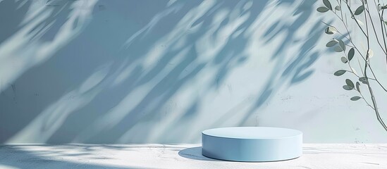 Round light blue podium under sunlight on a white table with leaf shadows in the background perfect for product presentations with copy space image