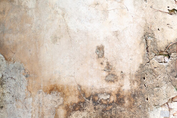 A close-up of a textured wall showcasing weathered plaster and visible stains, perfect for backgrounds or artistic projects.