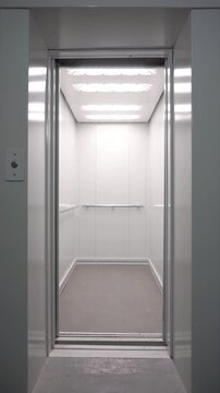 Opening elevator doors. Modern elevator or lift doors made of metal smoothly open and close. Empty elevator in a residential building or office