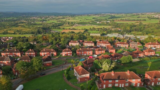 Yorkshire's housing district: Aerial drone shot of red brick council housing in the morning sun, showcasing residents and active streets in the UK.