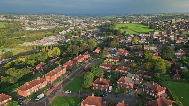 Council-run housing in Yorkshire: Red-brick buildings, aerial view, sunny morning, people walking, neighborhood life.