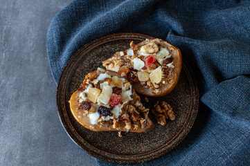 Baked pears with yogurt, honey, dried fruit and nuts, healthy autumn dessert