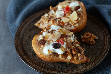 Baked pears with yogurt, honey, dried fruit and nuts, healthy autumn dessert