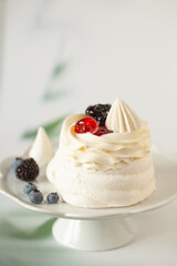 Mini Pavlova meringue nest with berries and whipped cream 