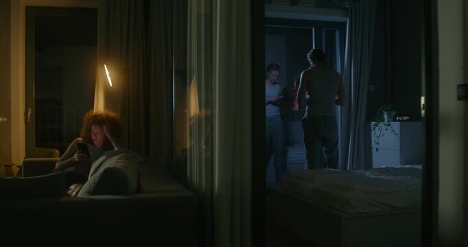 A man and a woman use mobile phones at night