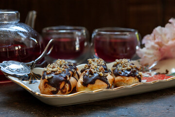 Classic chocolate eclair with custard cream and chopped walnuts on top