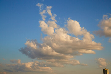 Large cumulus clouds in the light of the evening sun's rays in the sky