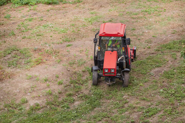 The tractor with the mower neatly clears the grass on the large field.