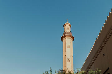 Fototapeta premium Mosque architecture on plane blue background with green tree underneath