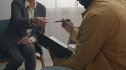 Female social worker finishing procedure of adoption with Black young couple and giving them folder with documents, they signing papers and handing them back