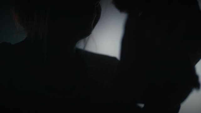 Upset mother hugging a teddy bear toy, missing her family and home, sadness