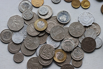 A variety of coins lying on a gray background.