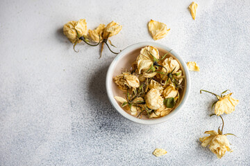 Dried roses in a bowl on a textured surface for decoration